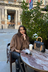 a lady in a brown tencel wool coat and a pair of black pants